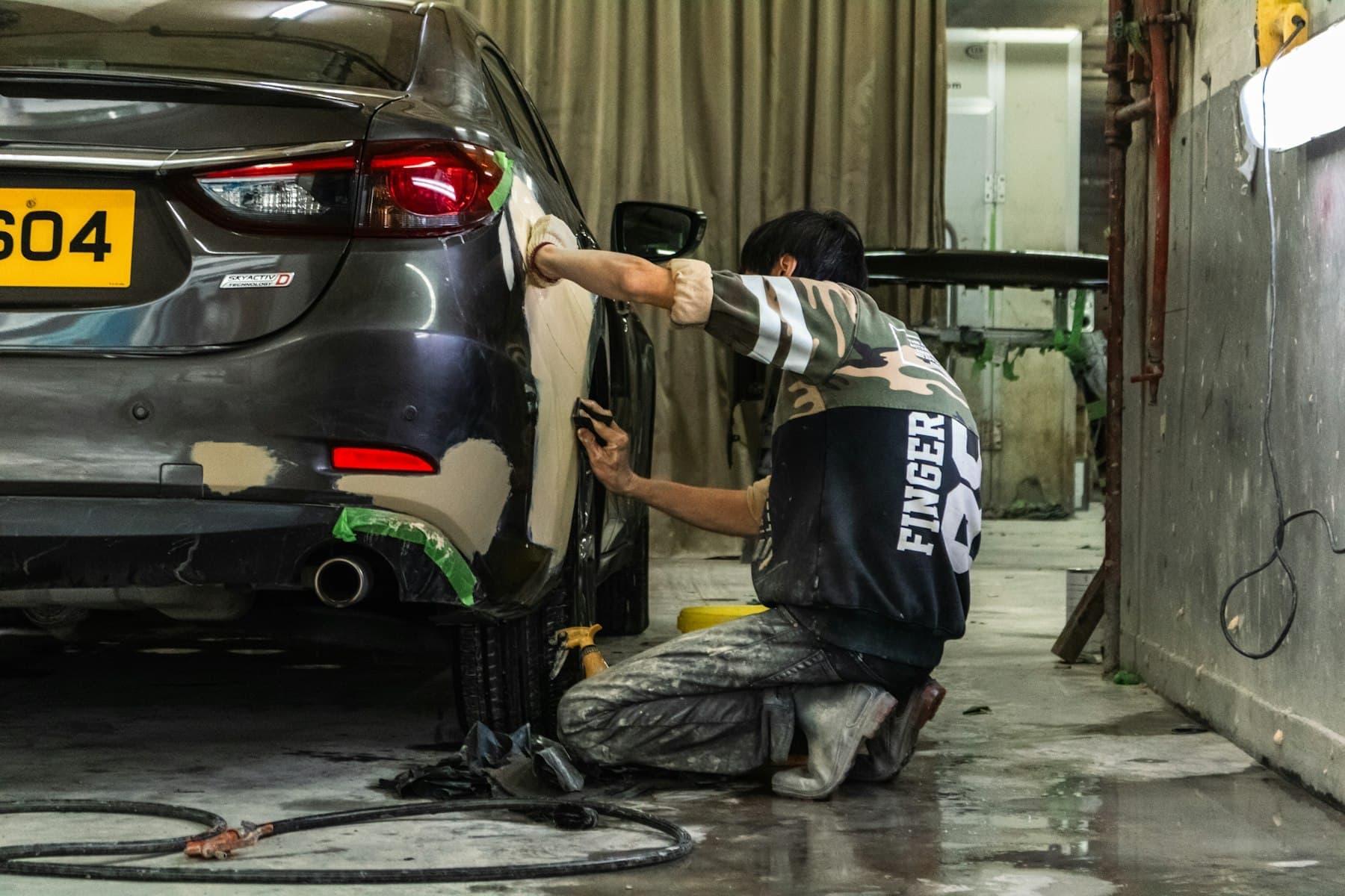 Car body panel being prepared and sanded before painting
